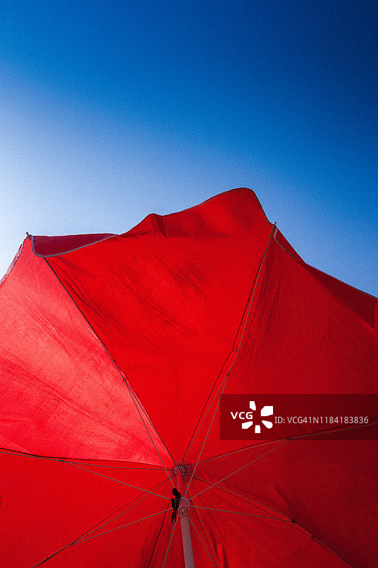 蓝色天空下的红色沙滩伞图片素材