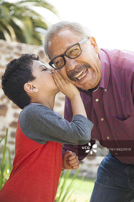 拉丁裔小男孩和爷爷说悄悄话图片素材