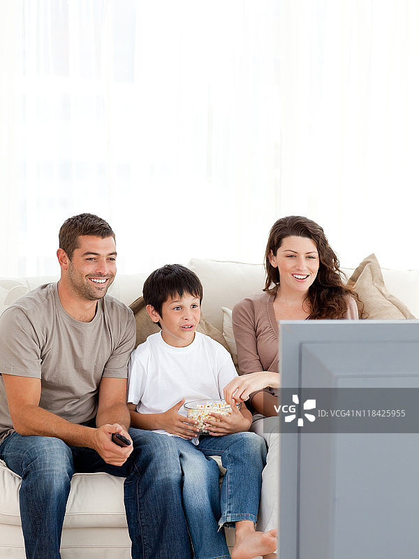 幸福的一家人一起吃着爆米花看电视图片素材