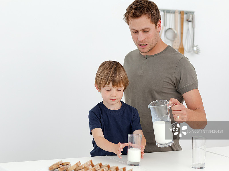 英俊男人给他的儿子喂牛奶图片素材