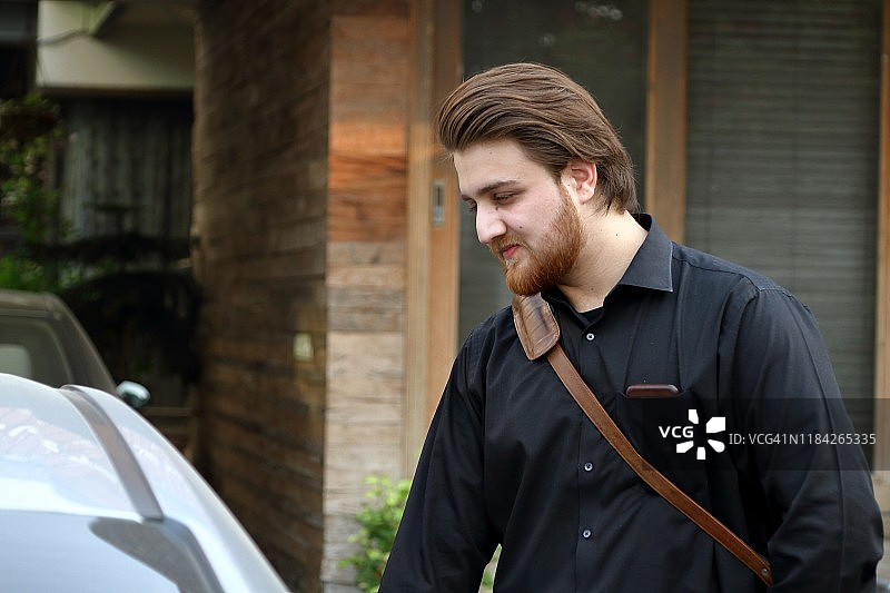 背公文包的年轻商人打开车门图片素材