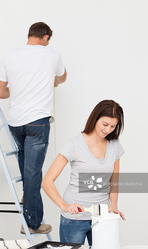 快乐情侣一起粉刷房间图片素材