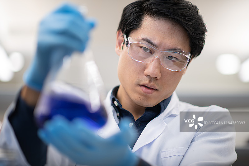 分析烧杯内物质的男性生物化学家图片素材
