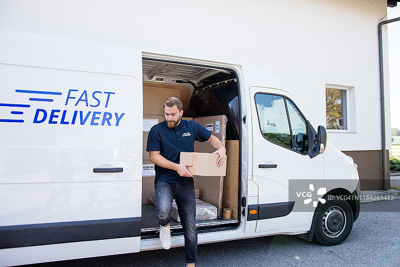 年长的男人从送货车上取包裹图片素材