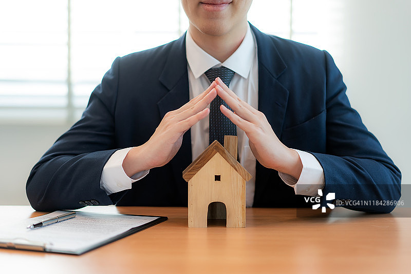 房地产保险经纪人保护房屋的木屋，财产保险概念图片素材
