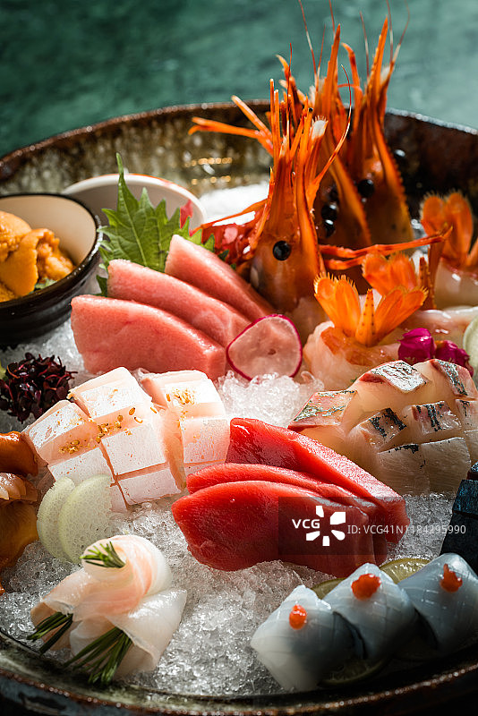 包含三文鱼、鰤鱼、金枪鱼和鱿鱼的刺身拼盘特写图片素材