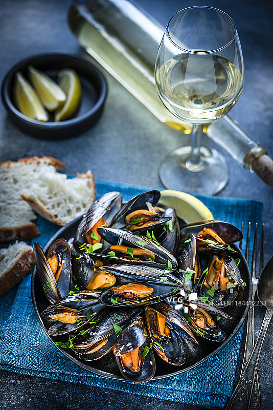 蓝底上的白葡萄酒蒸贻贝图片素材