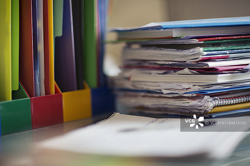 青少年卧室书桌上的学生课本、文件盘、文书和作业图片素材