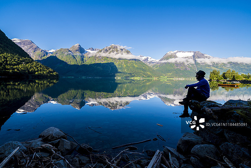 徒步者欣赏挪威Hjelle的Oppstrynsvatn湖图片素材