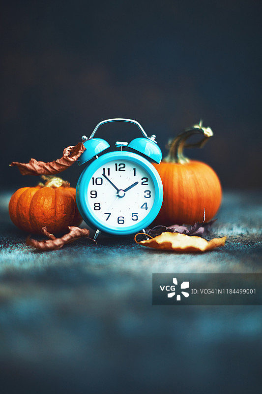 秋季时间：带有树叶和南瓜的闹钟，夏令时图片素材