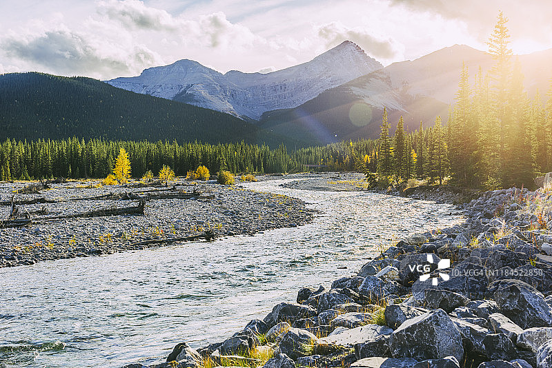 秋季奔腾的河流，远处是连绵的山脉图片素材