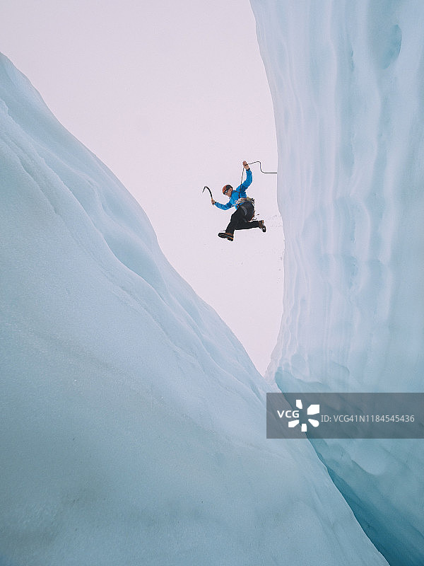 登山者跳跃大冰隙图片素材