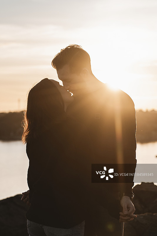 夕阳下情侣亲吻图片素材