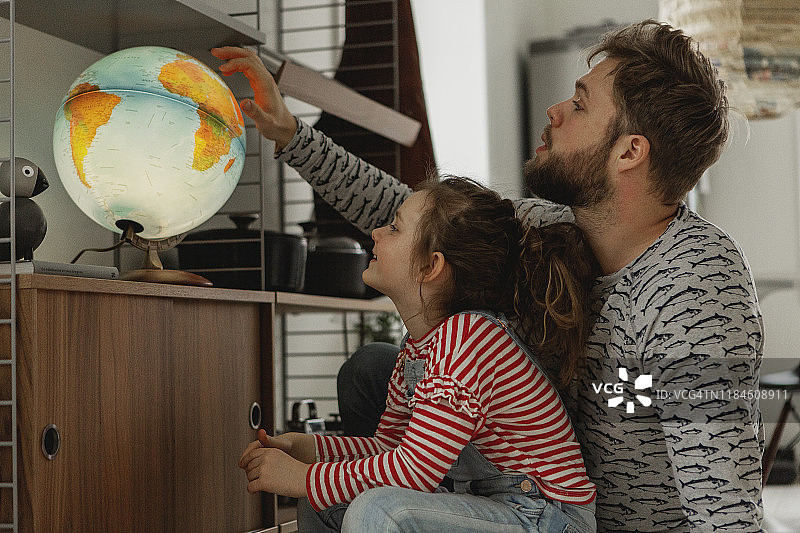 女孩和父亲一起看地球仪图片素材