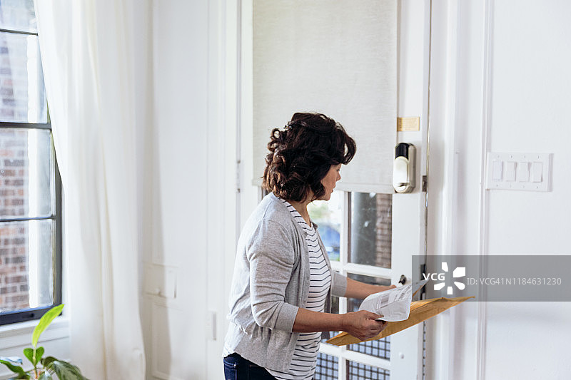 年长的女性从室外取包裹图片素材