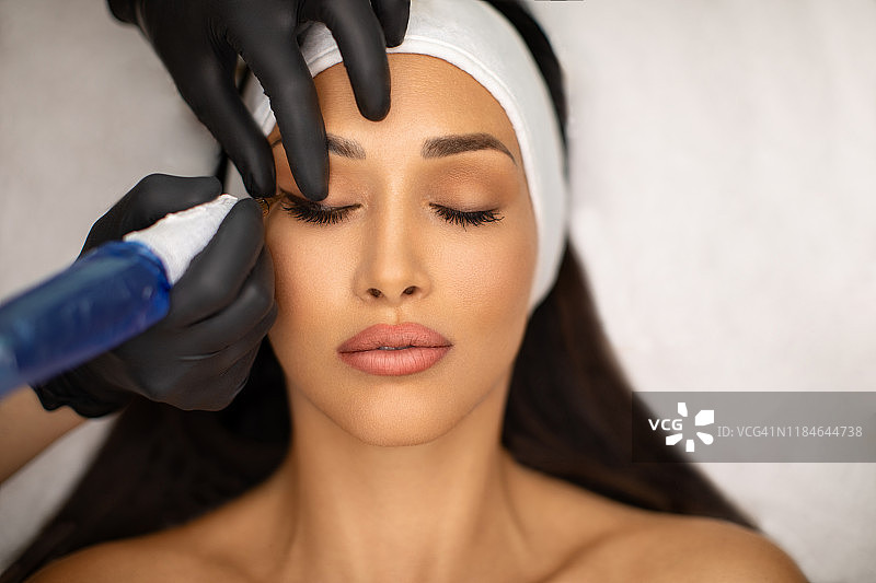 年轻女子接受永久化妆图片素材