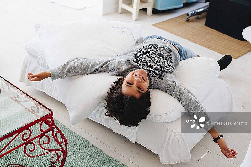 男孩在家中脚凳上放松图片素材