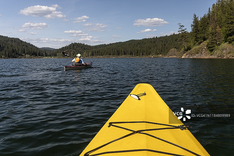 在科达伦湖上划黄色皮划艇图片素材
