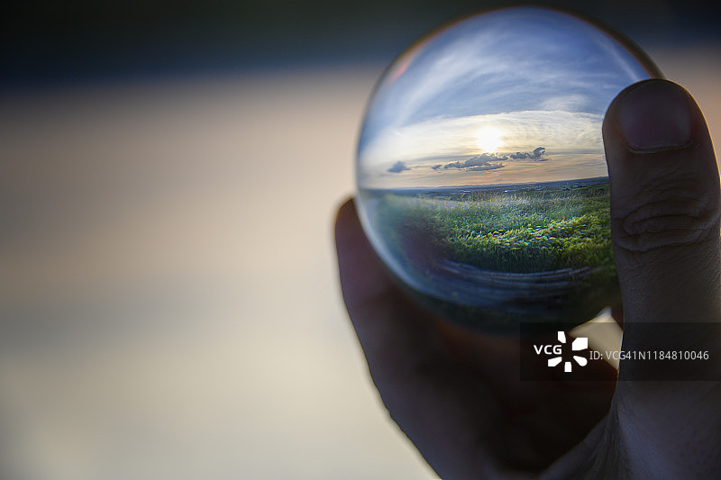 手持水晶球中的梦幻景观图片素材