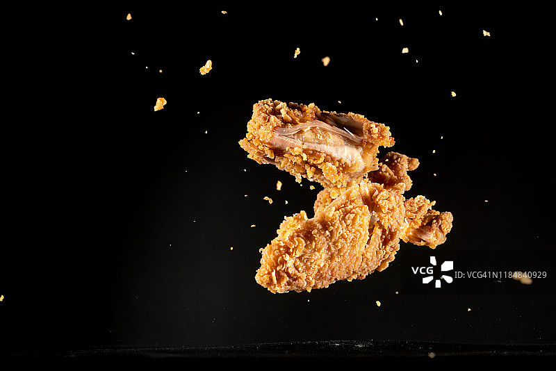 高速同步拍摄的飞在半空中的脆皮鸡肉图片素材