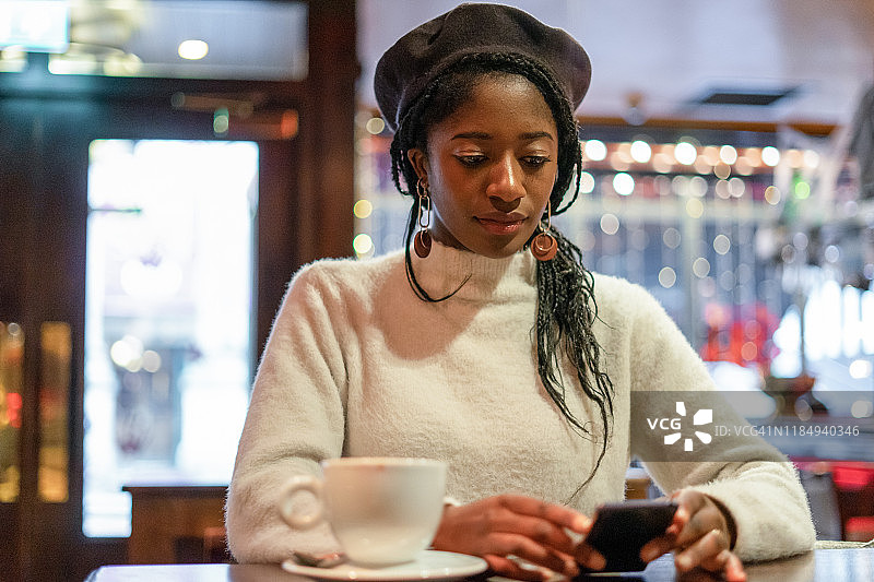 年轻女人在餐厅使用智能手机图片素材