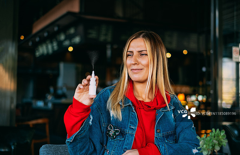 使用鼻腔喷雾剂的生病妇女图片素材