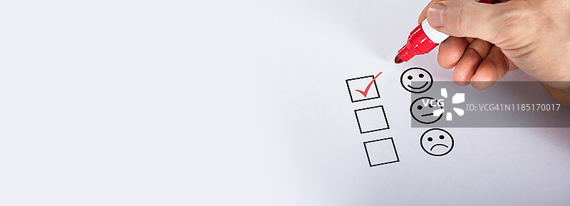 人的手在笑脸前的方框中打勾图片素材