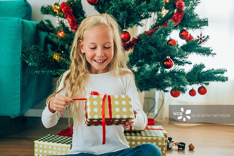 打开圣诞礼物的可爱女孩图片素材