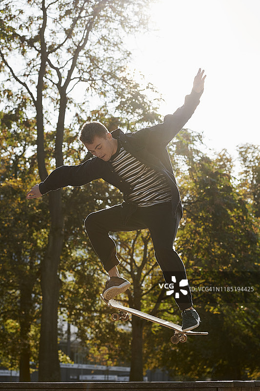 在公园里玩滑板的年轻男人图片素材