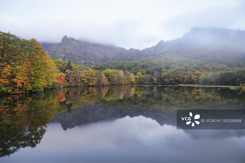 雾蒙蒙的早晨，风景池塘中倒映的秋色图片素材
