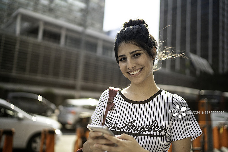 一名年轻女子使用智能手机的肖像图片素材