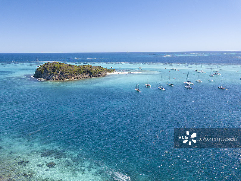 停靠在塔巴哥岛礁无人岛附近的帆船和双体船，格林纳丁斯，2019年图片素材