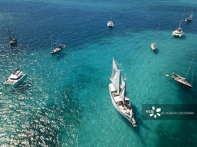 停靠在塔巴哥岛礁无人岛附近的帆船和双体船，格林纳丁斯，2019年图片素材