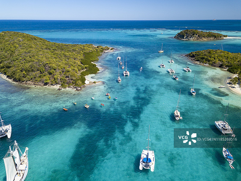 停靠在塔巴哥岛礁无人岛附近的帆船和双体船，格林纳丁斯，2019年图片素材