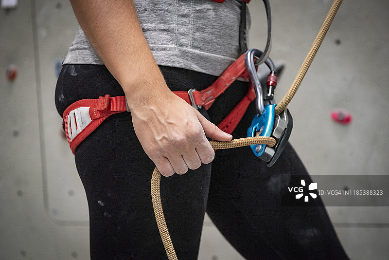 年轻女子调整攀岩绳索图片素材