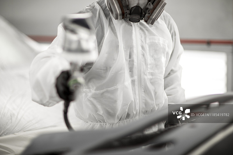 汽车维修店技师用喷枪喷涂汽车零件图片素材