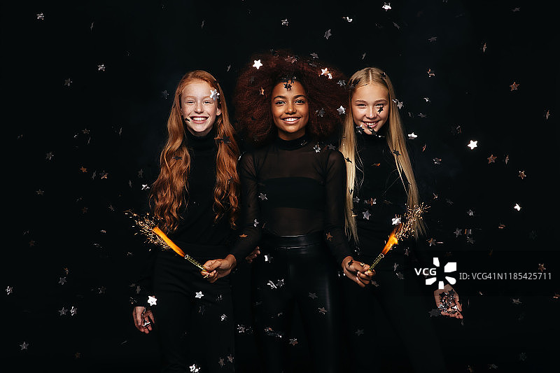 三个快乐的年轻女孩庆祝新年图片素材