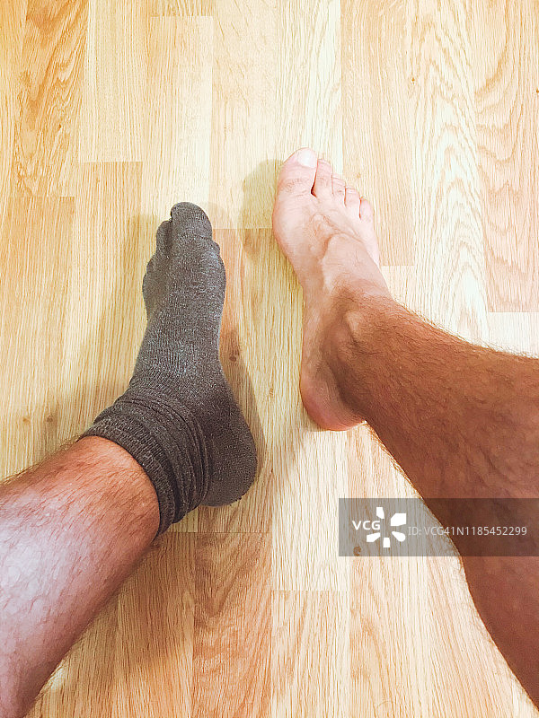 男子的脚，从上方拍摄，只穿了一只袜子图片素材