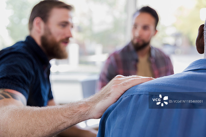 中年男人在治疗期间安慰朋友图片素材