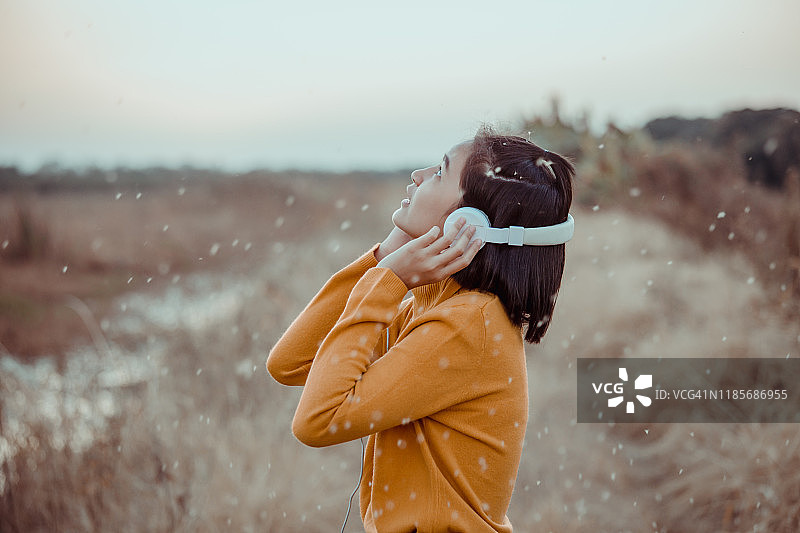 戴着耳机听音乐的亚洲女孩图片素材