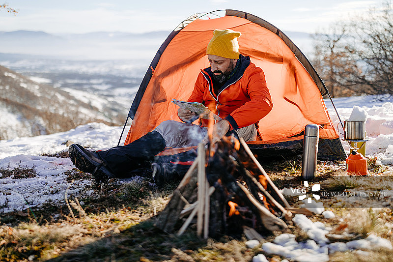 男子在冬日雪山中露营图片素材