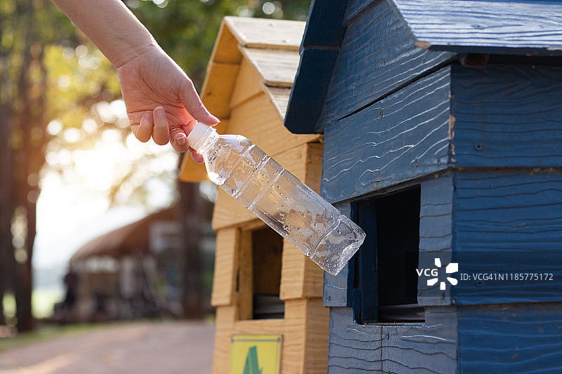 世界环境日：女性将塑料瓶放入垃圾桶图片素材