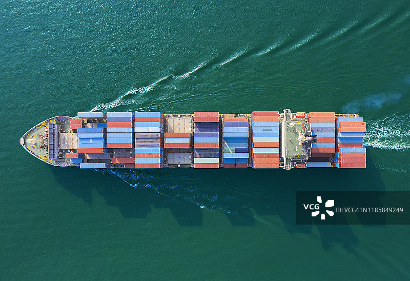 全速集装箱货轮空中俯瞰图：波浪优美，用于商业物流、进出口运输图片素材