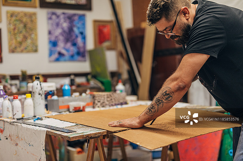 男人用刻刀切割画布图片素材