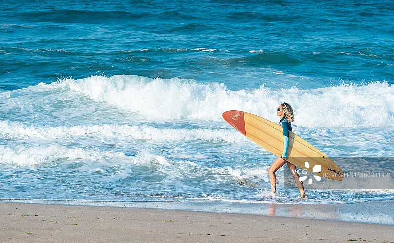 携带冲浪板的美丽冲浪者图片素材