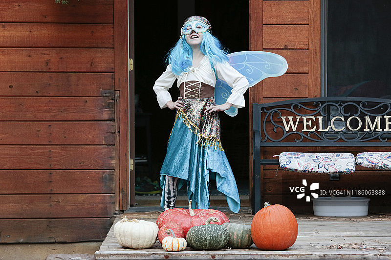 年轻女孩的蓝色仙女万圣节服装，带面具和翅膀图片素材