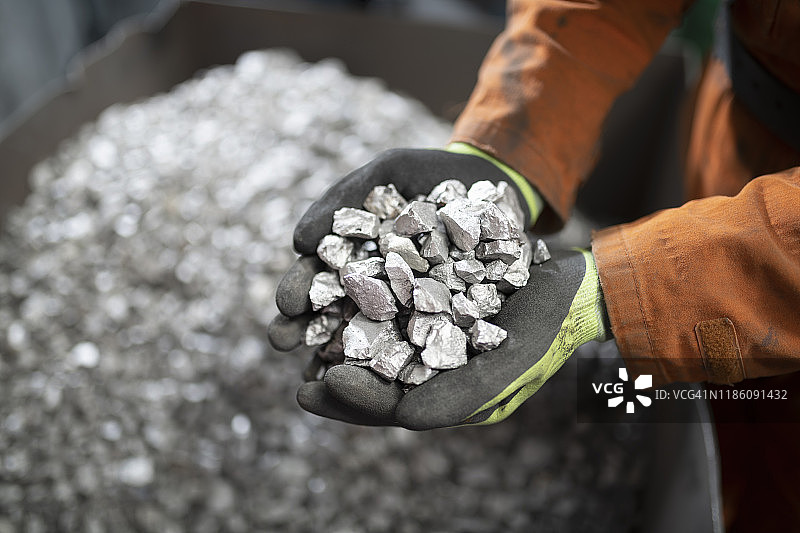 工人在钛回收厂粉碎车间手持钛样品特写图片素材
