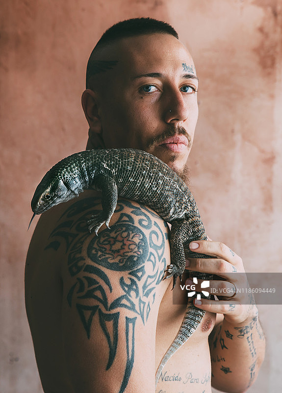 有着蓝色眼睛，肩上纹着蜥蜴的男人图片素材
