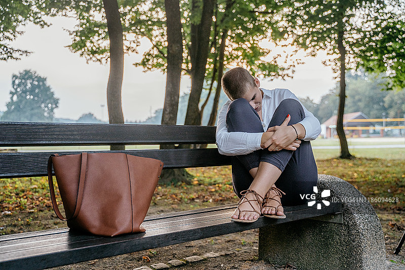 坐在长椅上悲伤沮丧的女商人图片素材
