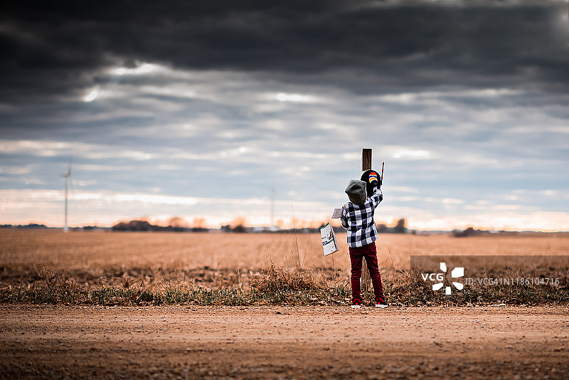 小男孩在土路上从邮箱里取邮件图片素材